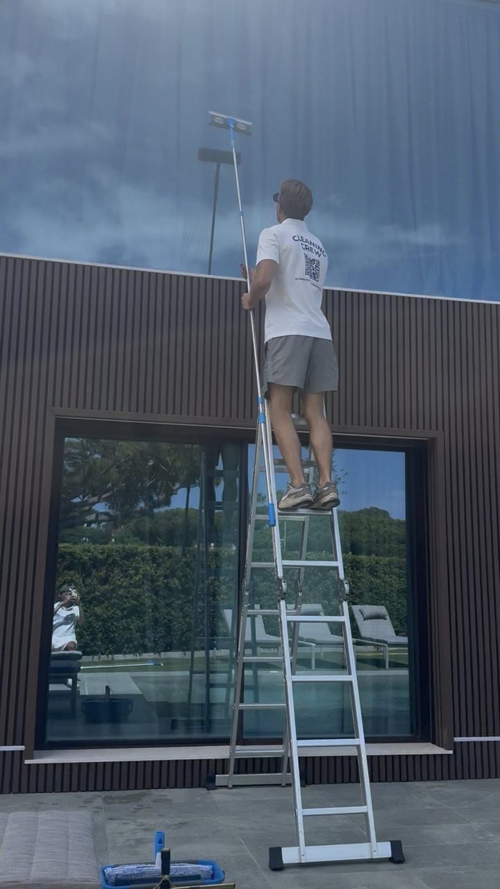 High-level glass cleaning from a ladder at a villa in Vale do Lobo